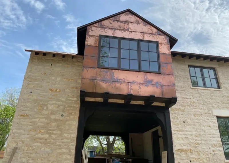 Copper metal panel facade on a stone building for Skylight Installation in Marathon